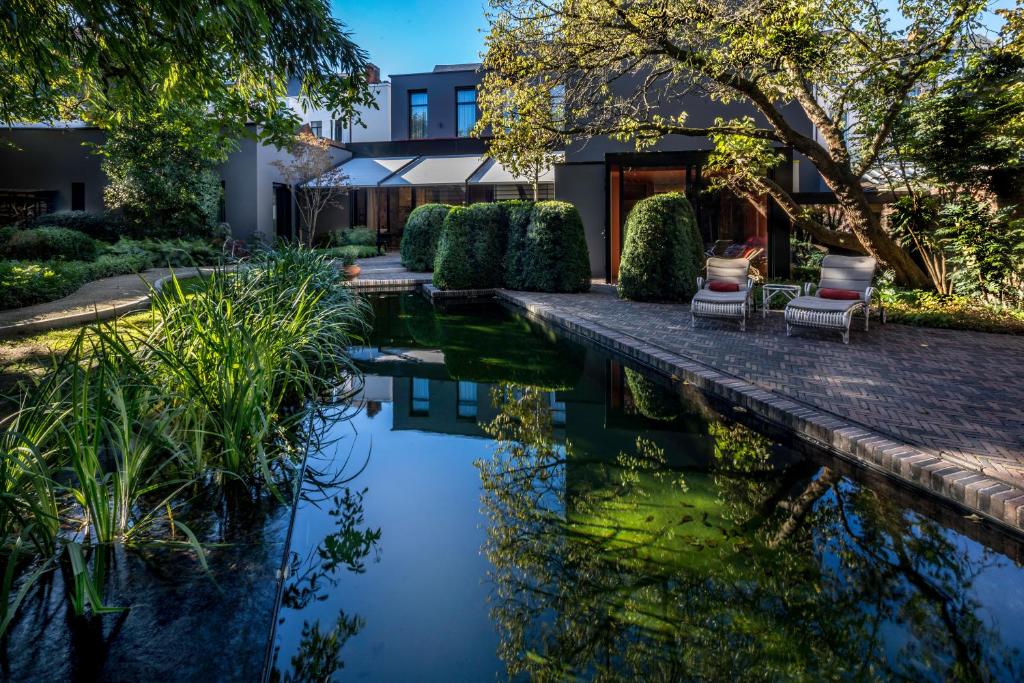 a house with a pond in front of it at Cabosse, Suites & Spa in Antwerp