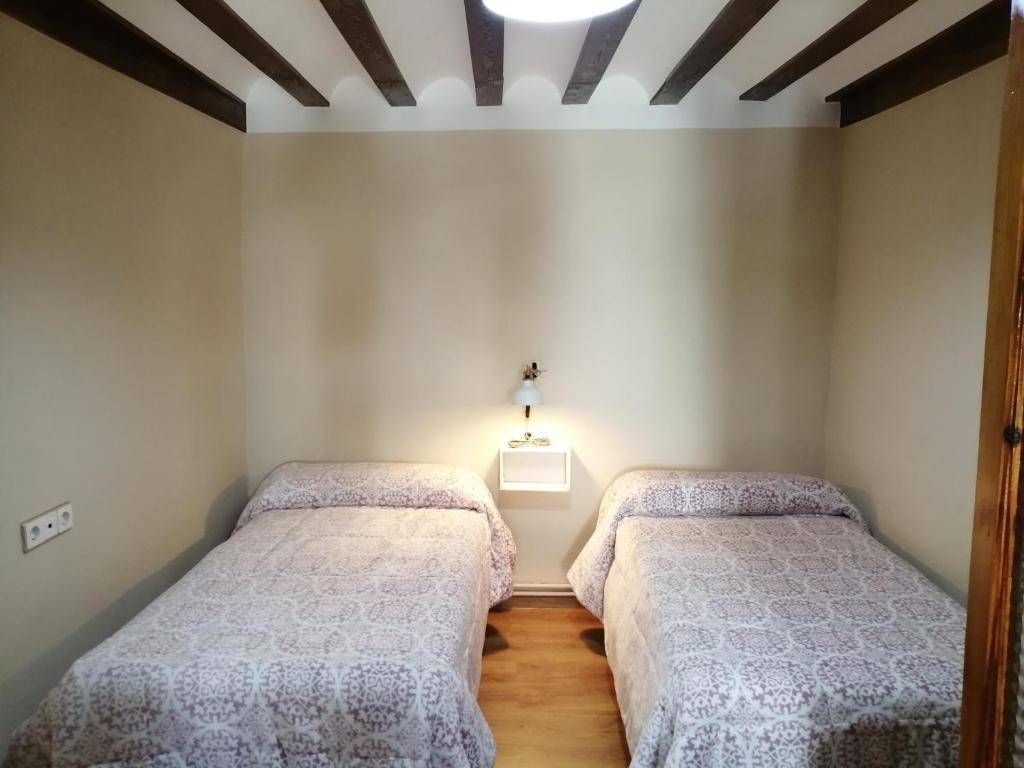 1 dormitorio con 2 camas y una luz en la pared en LA TRASTIENDA de felipe en Pontones