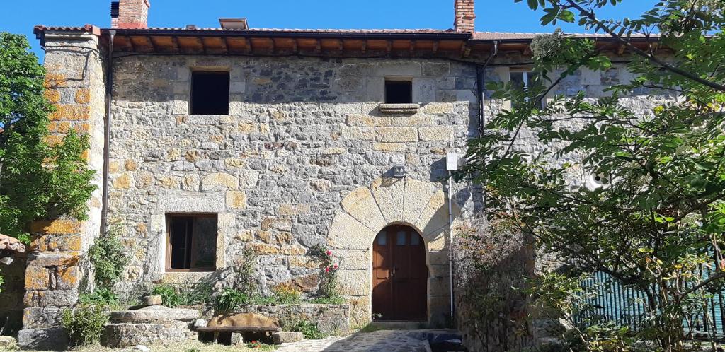 an old stone building with a door and a gate at La Casa del Diezmo de la Montaña Palentina in Redondo