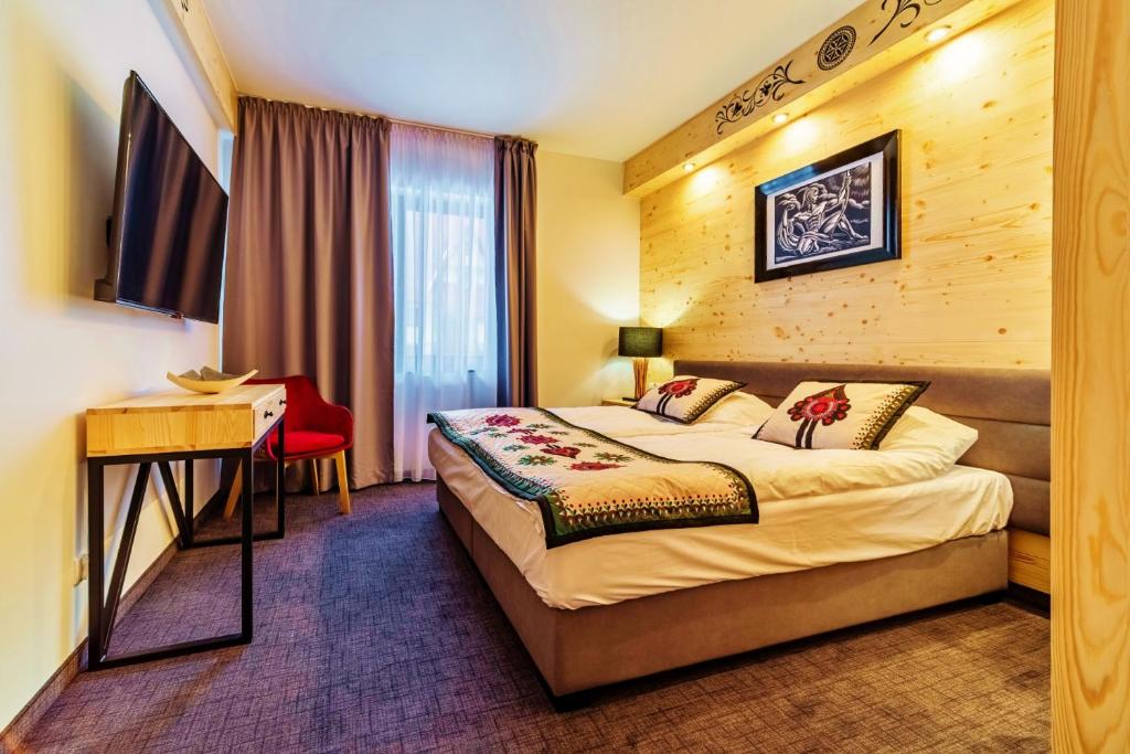 Cette chambre comprend un lit et un bureau. dans l'établissement Apartamenty Góralskie Zakopane, à Zakopane