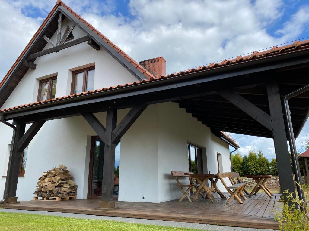 a house with a wooden deck and a roof at Sterburta in Rydzewo