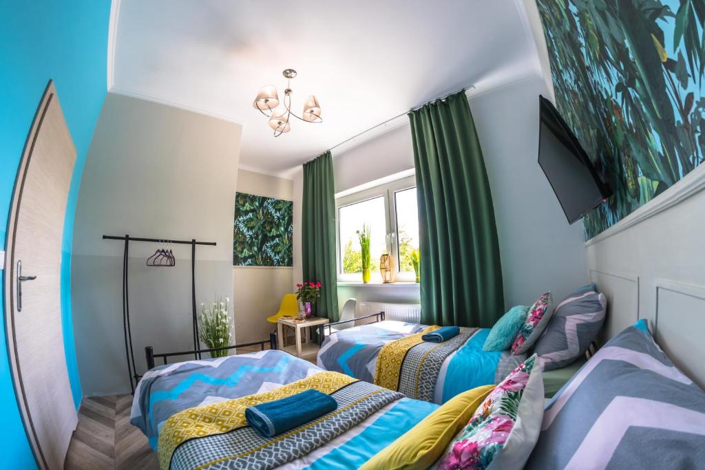 two beds in a room with blue walls at Pokoje Hotelowe Siedlczanka in Siedlce
