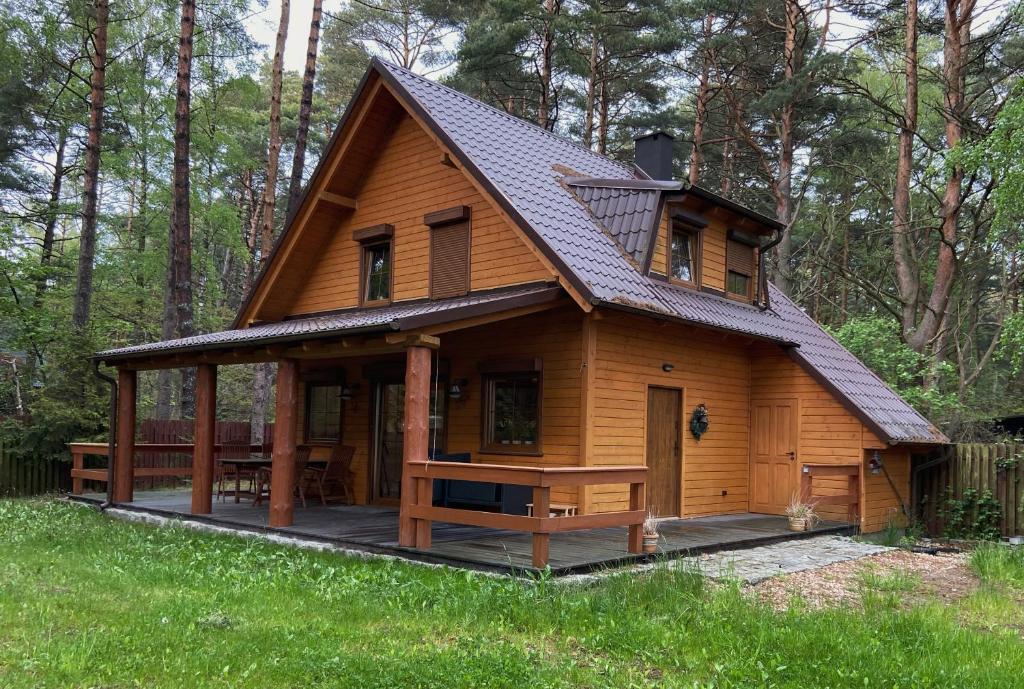 a large wooden cabin with a gambrel roof at Sea Zone Domek całoroczny przy plaży in Dębki