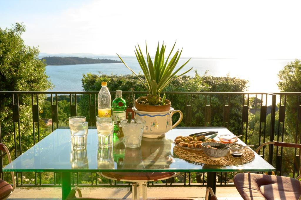 szklany stół z rośliną na balkonie w obiekcie Panorami sul Trasimeno w mieście San Feliciano