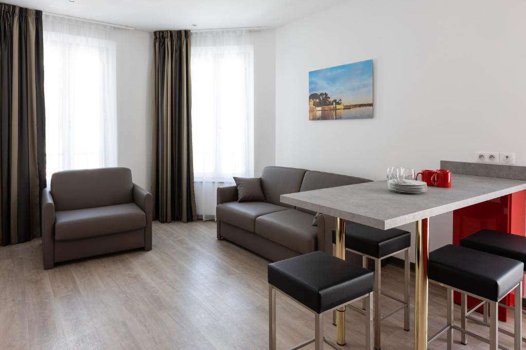 ein Wohnzimmer mit einem Tisch und Stühlen in der Unterkunft Appartements French Riviera Confidential Centre Ville Juan les Pins proche des plages in Juan-les-Pins