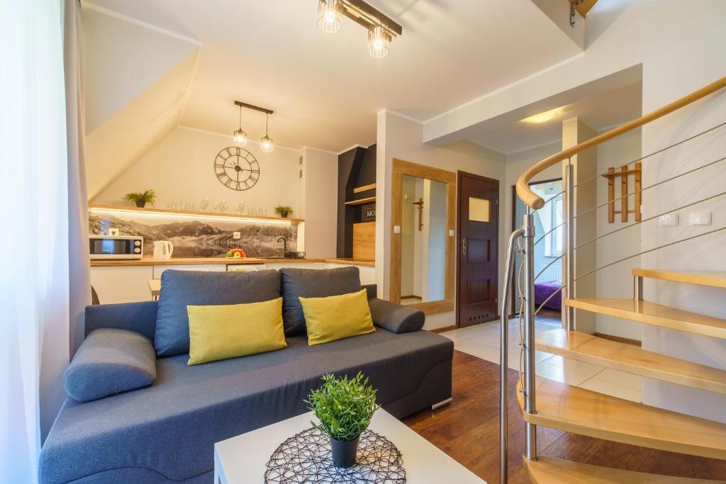 un soggiorno con divano blu e una cucina di Apartamenty Montana a Zakopane