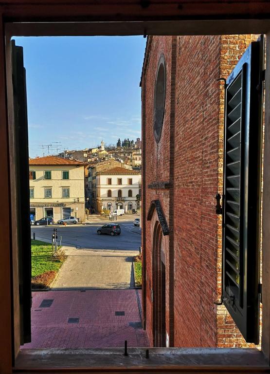 a window view of a street from a brick building at APPARTAMENTS SAN FRANCESCO in Castelfiorentino