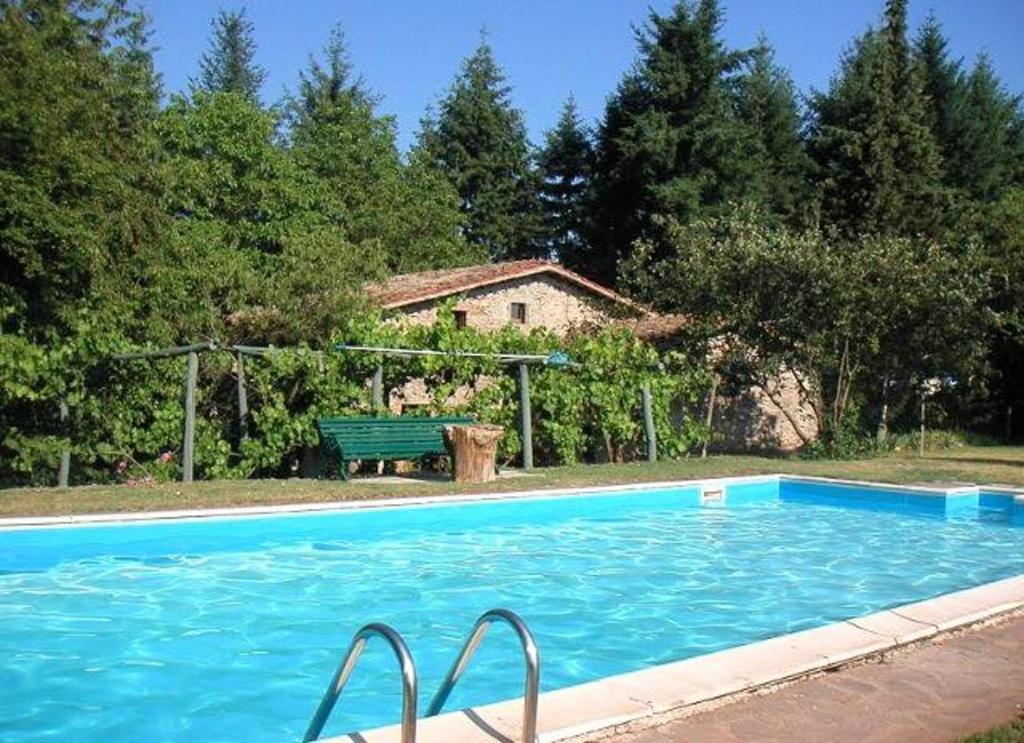 a swimming pool with a bench next to a house at 3 bedrooms villa with private pool furnished garden and wifi at Barga in Barga