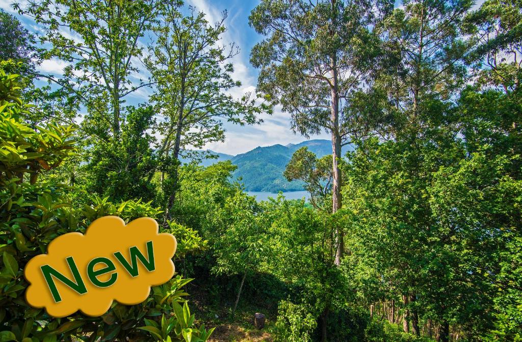 a new sign in the trees with a view of a lake at Welcome to Gerês-Green view in Vieira do Minho