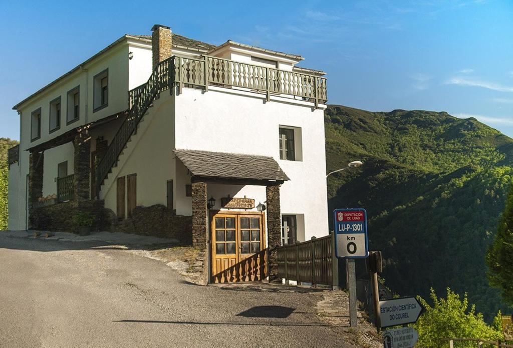 un bâtiment avec un balcon sur le côté d'une route dans l'établissement Casa Ferreiro, à Seoane