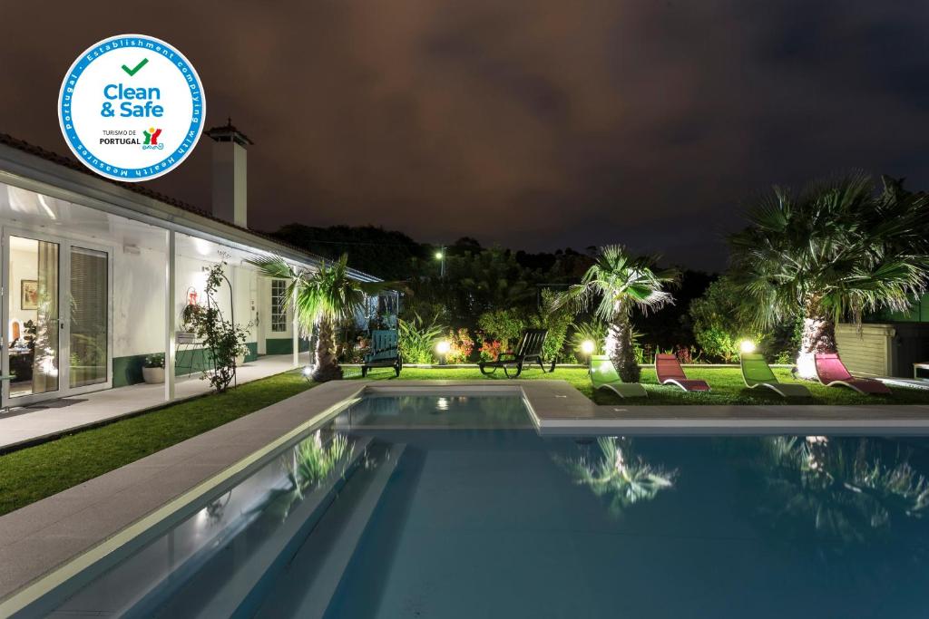 a villa with a swimming pool at night at Quinta de Santa Bárbara Casas Turisticas in Lagoa