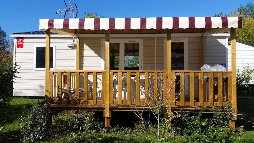 a tiny house with a porch and a awning at Bungalow charmant à Onzain avec vue sur jardin in Onzain