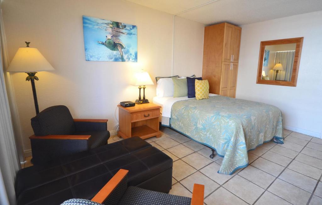 ein Hotelzimmer mit einem Bett und einem Sofa in der Unterkunft Sea Shore 75 Steps from Waikiki Beach and Sleeps 1 - 3! in Honolulu