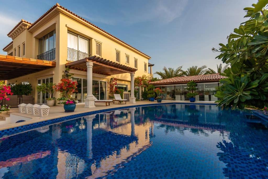 a swimming pool in front of a house at Villa Lazuli - Saadiyat Island - A one-of-a-kind stay, with jacuzzi and pool - limited to 12 in Abu Dhabi