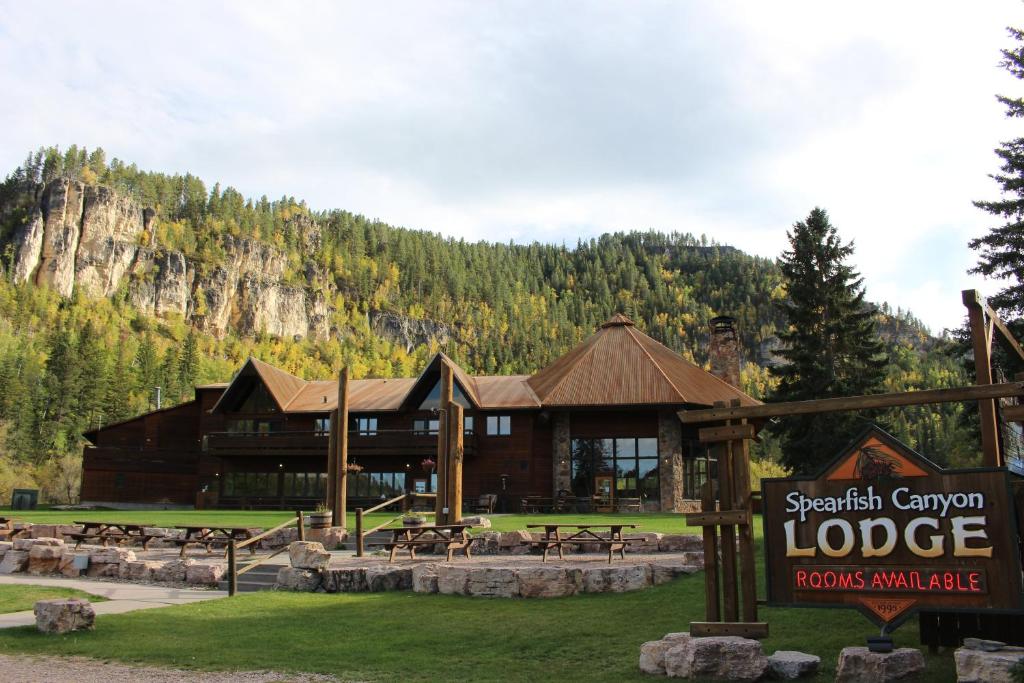 Un gran edificio con un cartel delante. en Spearfish Canyon Lodge, en Spearfish