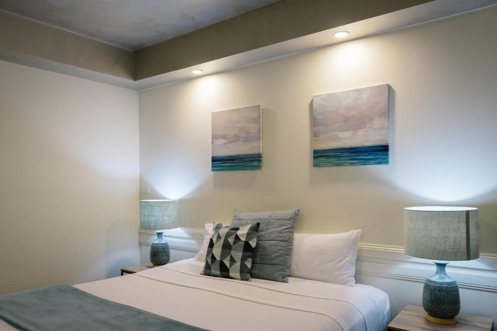 a bedroom with a bed and two paintings on the wall at Fairways Resort in Rosebud