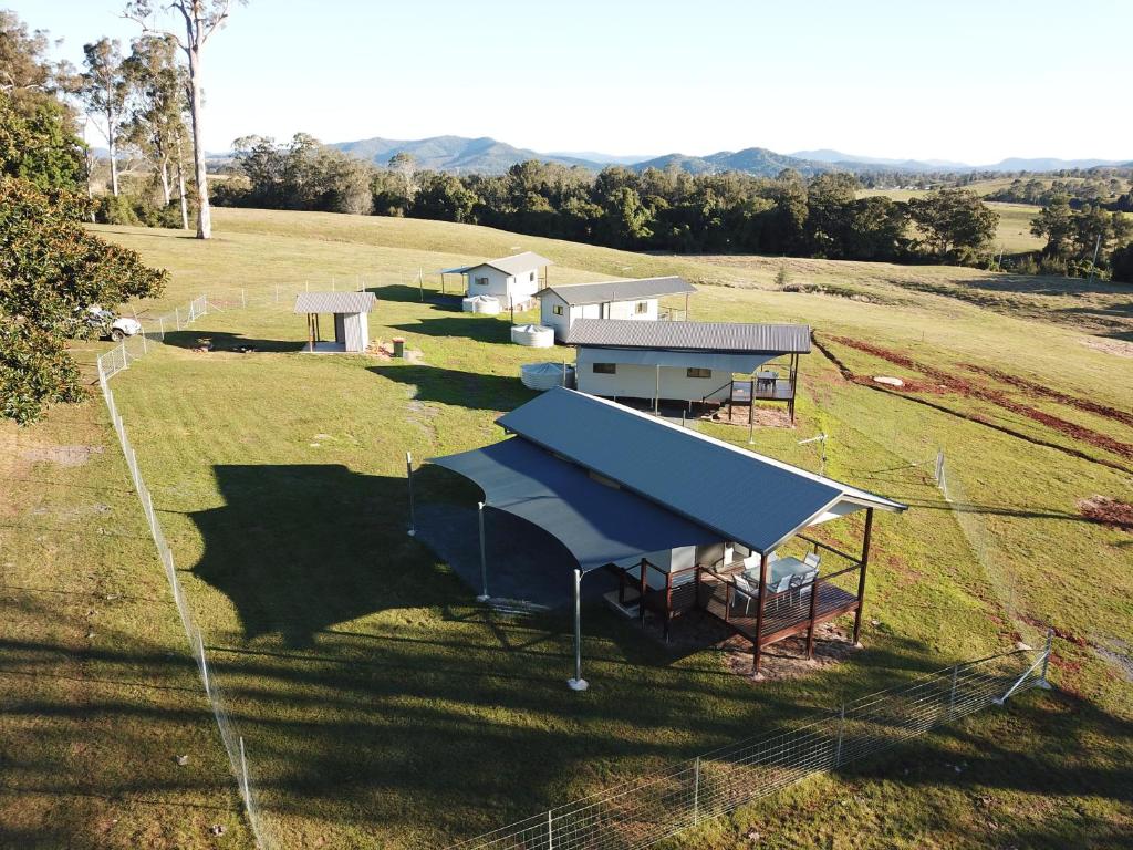 an overhead view of a group of buildings in a field at Valley Cabins By The Creek in Imbil