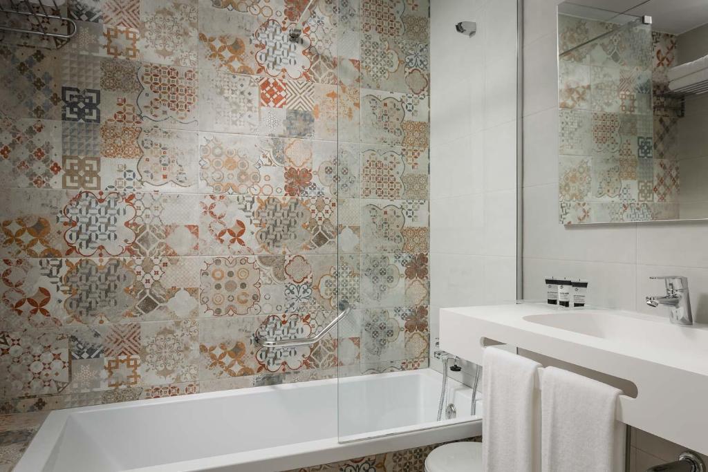 a bathroom with a bath tub and a sink at Hotel Boutique Calas de Alicante in Alicante