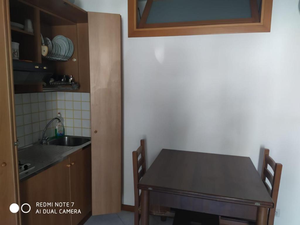 cocina con mesa de madera y fregadero en Casa Totano, en Canneto