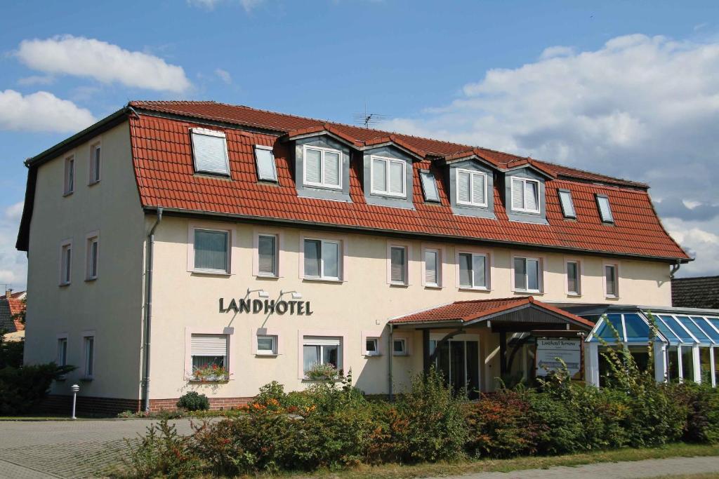 ein großes weißes Gebäude mit rotem Dach in der Unterkunft Landhotel Turnow in Turnow