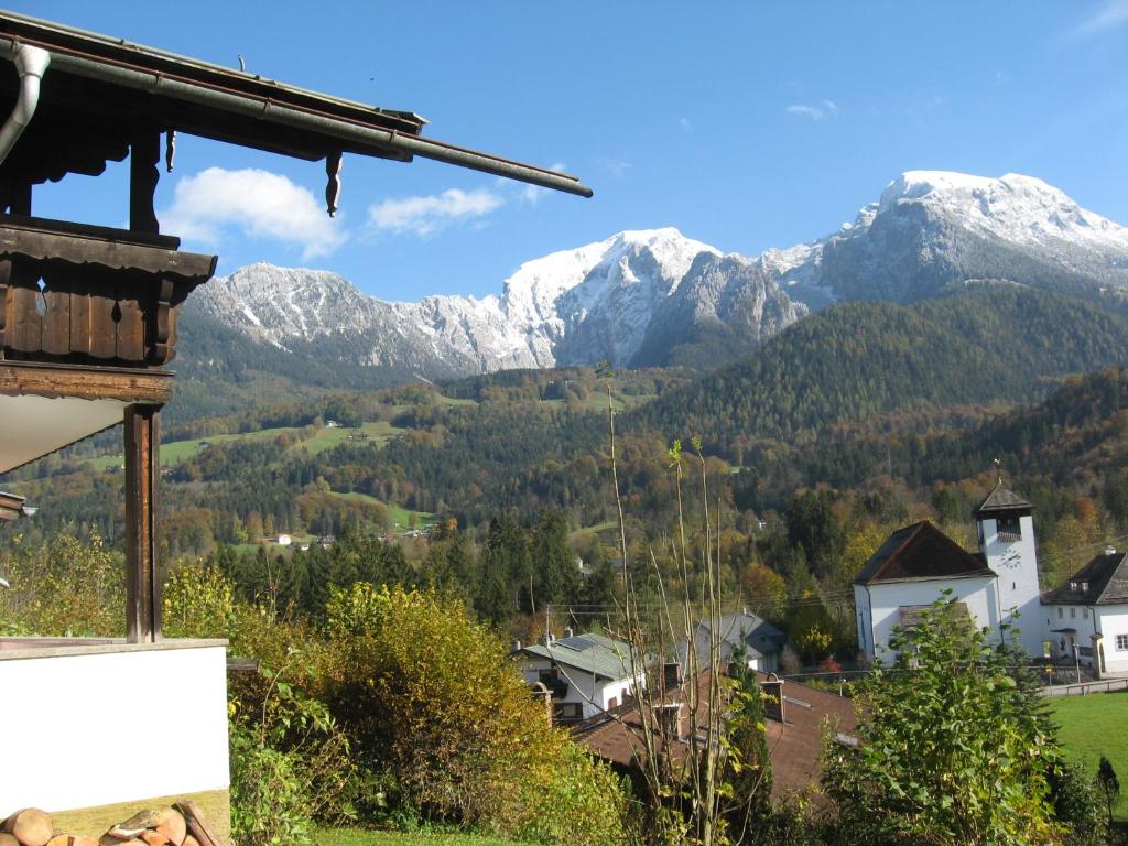 a view of snowy mountains from a village at Bio & Vegi Pension Krennleiten in Schönau am Königssee