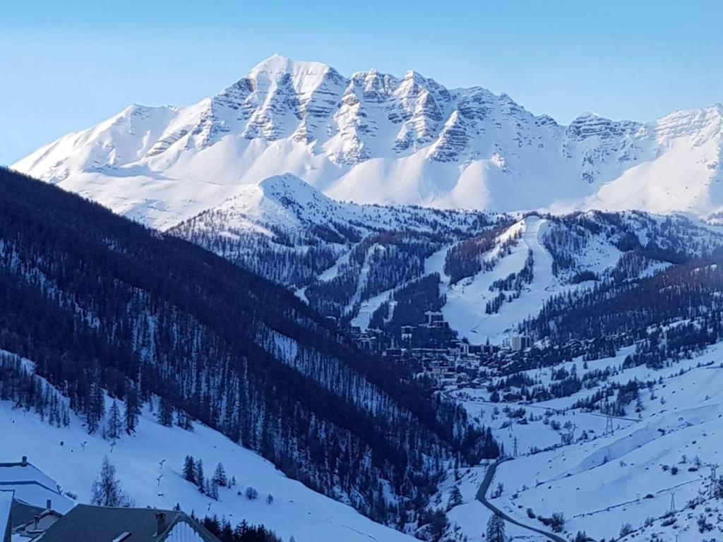 a snow covered mountain with a town in front of it at Appartement de 3 chambres avec balcon et wifi a Vars a 2 km des pistes in Vars