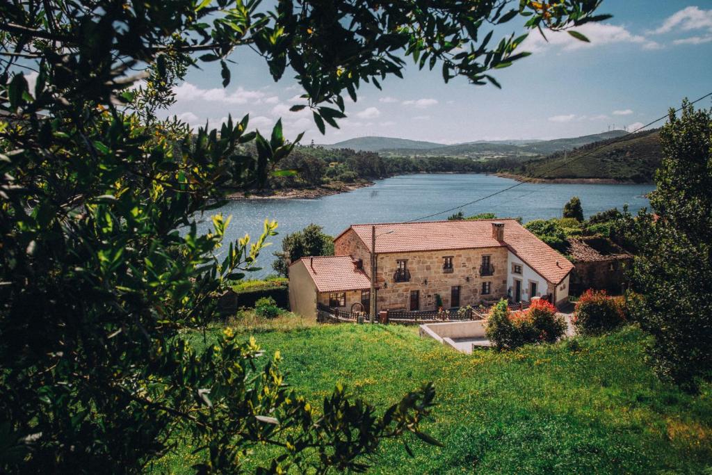 an old house with a view of a river at Casa de Santa Uxía in Ézaro