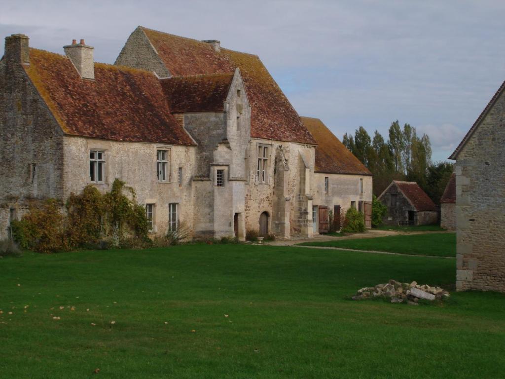 een oud stenen huis met een grote grastuin bij Manoir de la Baronnie in Marcei