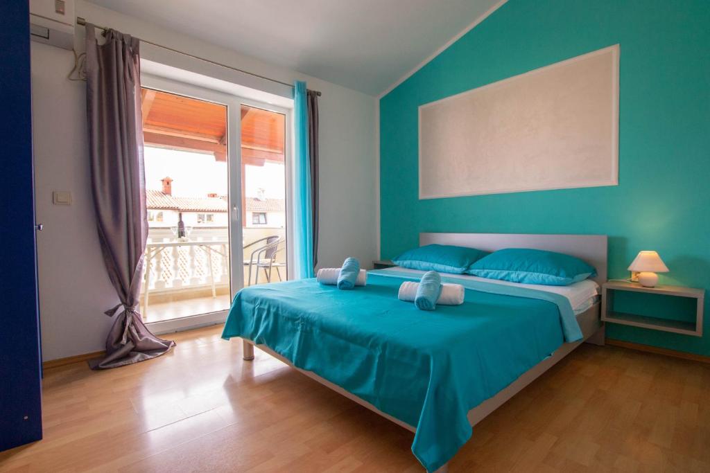 um quarto azul com uma cama e uma janela em Cozy apartment with breakfast on request 1 em Pula