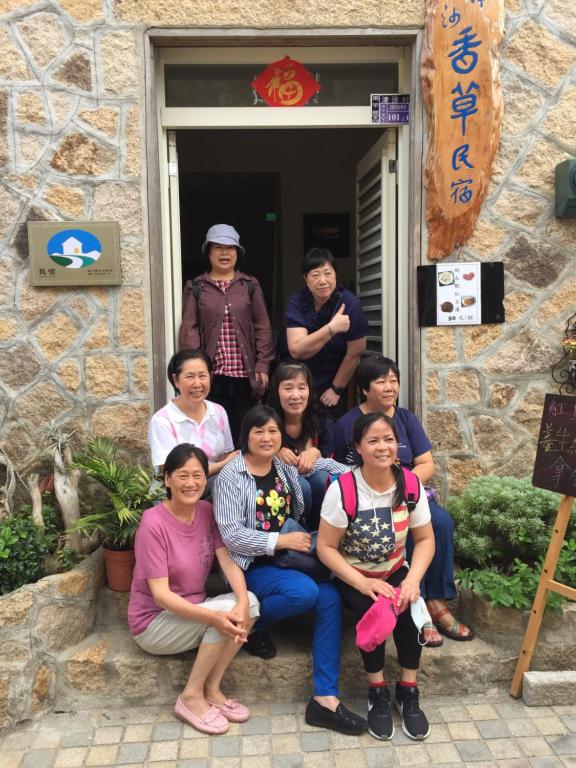 a group of people posing in front of a building at Jinsha Vanilla Homestay in Nangan