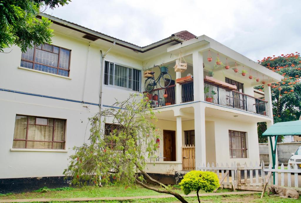 a white house with a balcony at Wakawaka House in Arusha