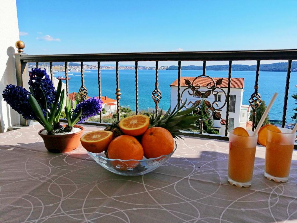 a bowl of oranges on a table with a view of the ocean at LibeTrogir in Trogir