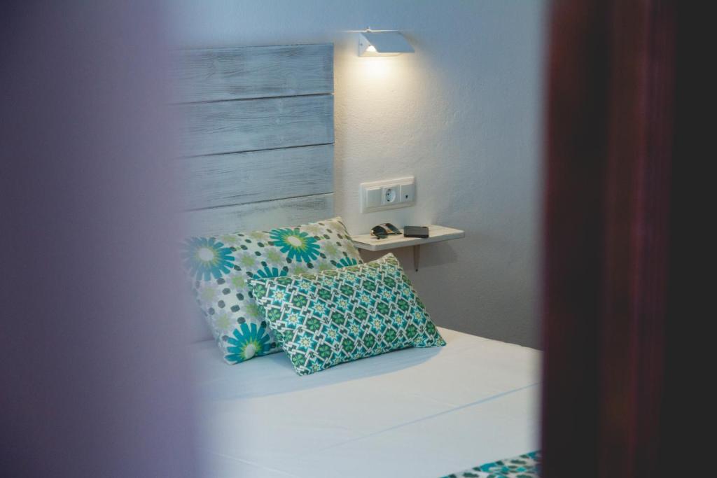 a bedroom with a bed with two pillows on it at Hotel Avenida Playa in Zahara de los Atunes