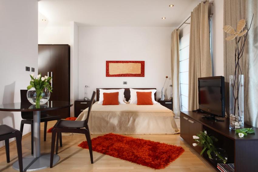 a bedroom with a bed and a desk and a television at Hotel Villa Annette in Rabac
