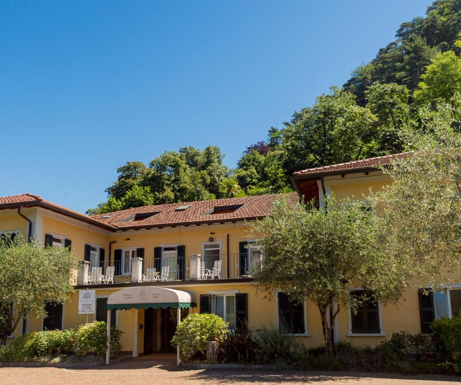 een gebouw met bomen voor een berg bij Residence L'Ulivo in Bellagio