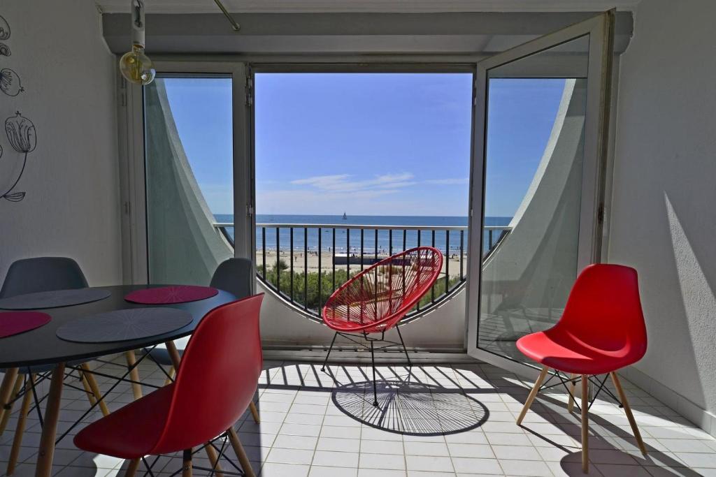 einen Balkon mit einem Tisch und Stühlen sowie Meerblick in der Unterkunft Studio de 33 m2, vue et bord de mer, parking in La Grande-Motte