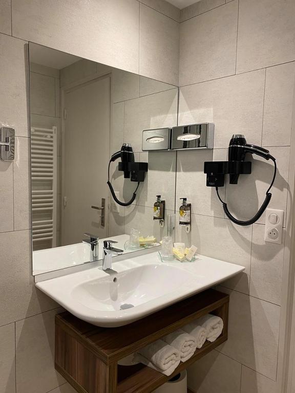 a bathroom with a sink and a mirror at Hotel Europa in Quiberon