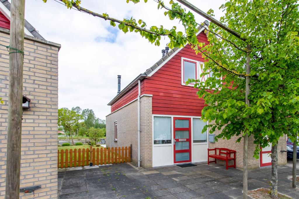 ein rot-weißes Haus mit einer roten Tür in der Unterkunft Antibes 262 - Kustpark Village Scaldia in Hoofdplaat