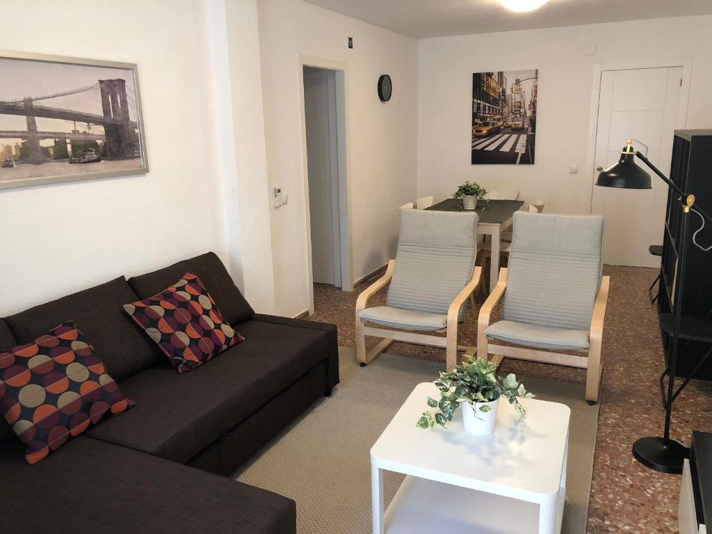 - un salon avec un canapé, deux chaises et une table dans l'établissement Céntrico apartamento para 6 en Benidorm, à Benidorm