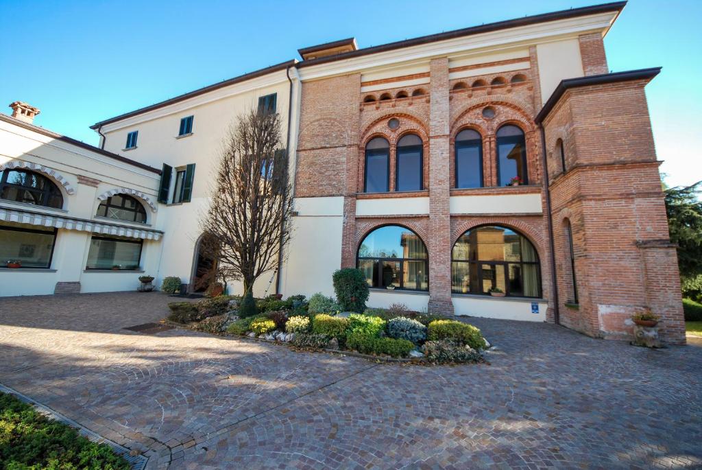 a large brick building with a courtyard at Villa Santa Maria dell'Arco - Centro Oreb in Cazzago San Martino
