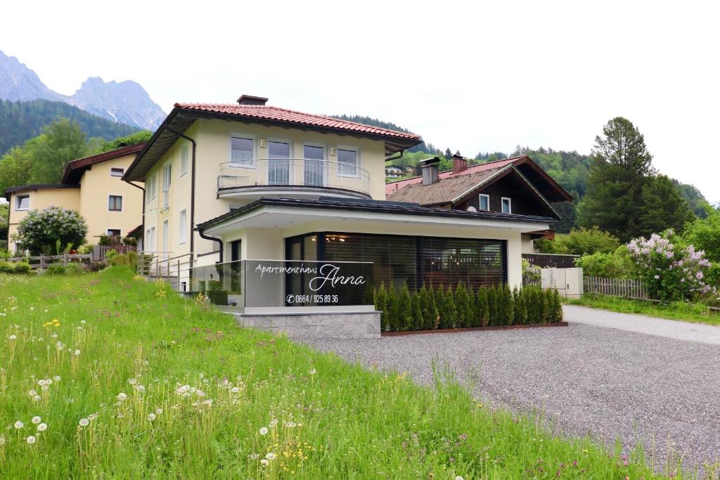 a house on a hill with a sign in front of it at Appartementhaus Anna in Leogang