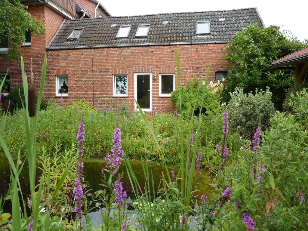 a garden with purple flowers in front of a brick building at Ferienwohnung Radszys in Bleckede