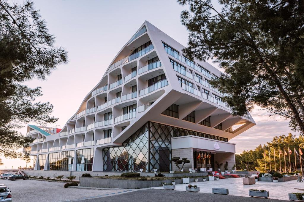 um grande edifício branco com uma fachada em pirâmide em Prince Adriatic Resort em Shëngjin