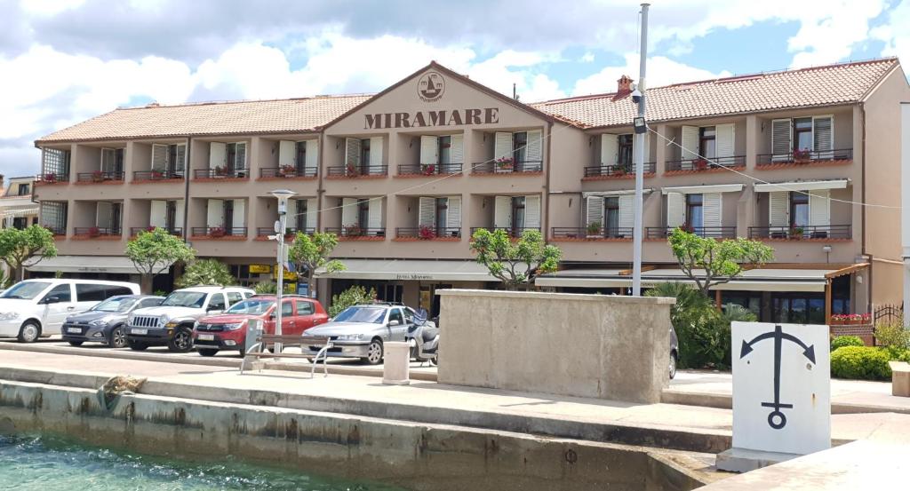 un hotel con auto parcheggiate di fronte di Hotel Miramare a Njivice