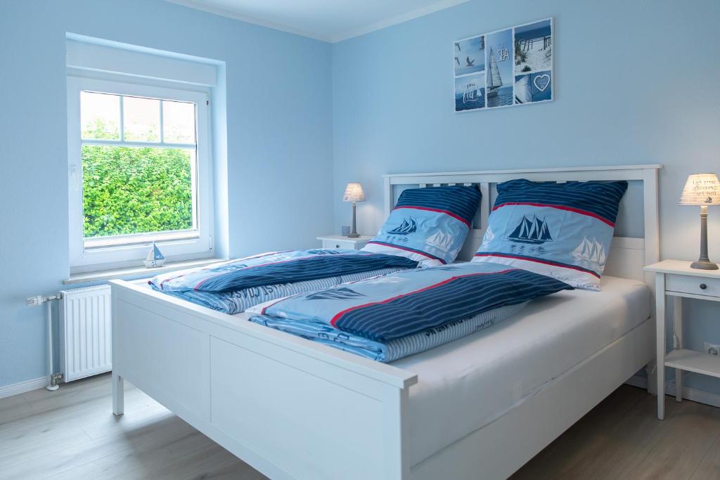 屈赫隆斯博爾恩的住宿－Villa Vineta，一间卧室配有一张蓝色墙壁的床和一扇窗户