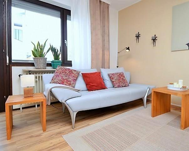 a white couch with red pillows in a living room at Riesling - helle und großzügige Wohnung mit guter Anbindung in Mainz