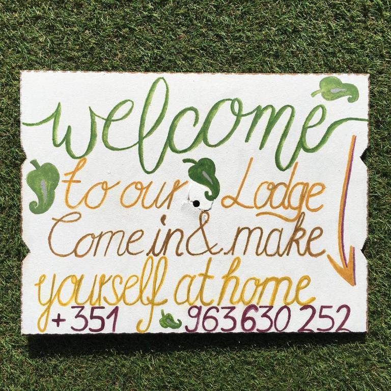 a welcome sign sitting on the grass at Carrapateira Lodge in Carrapateira