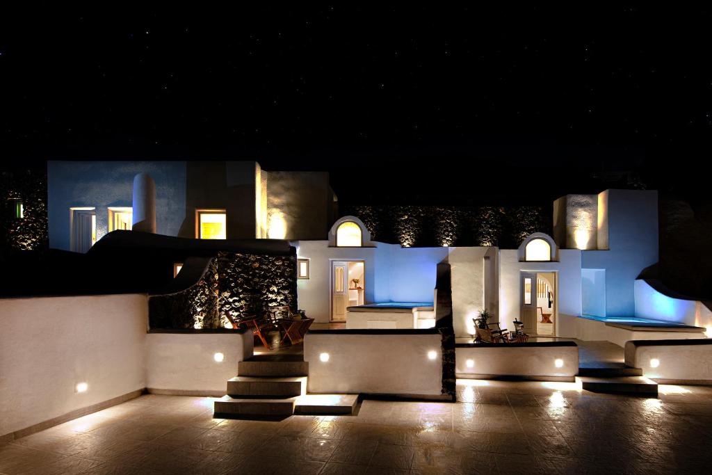 una casa iluminada por la noche con luces en San Martino cave villas, en Pirgos