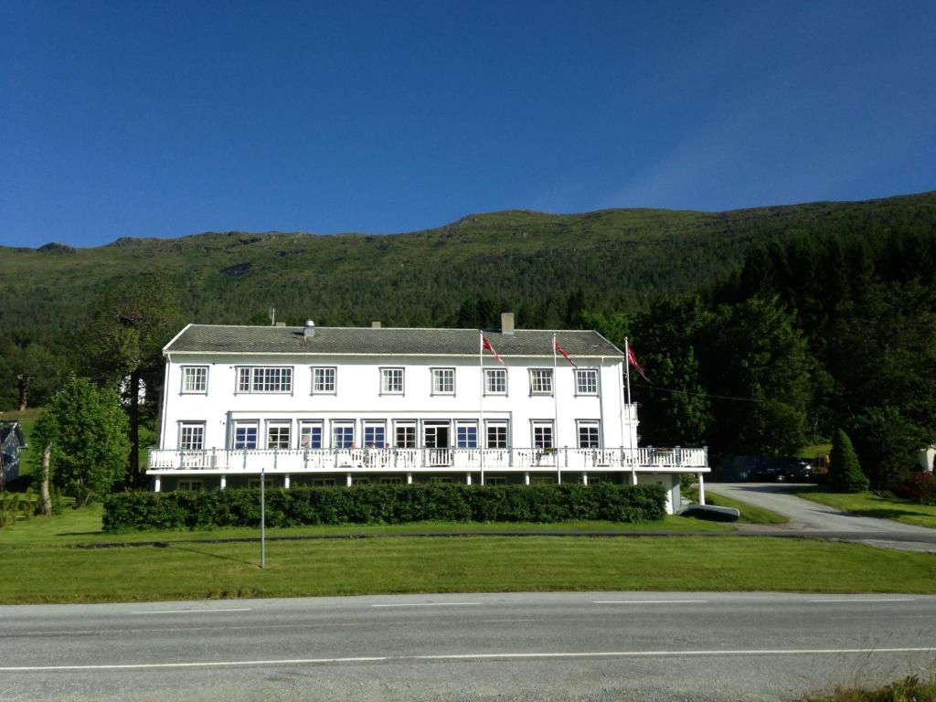 a large white house on the side of a road at Eidsvåg Fjordhotell in Eidsvåg