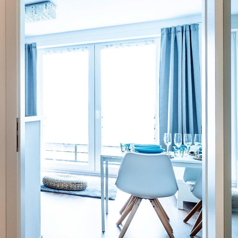 ein Esszimmer mit einem Tisch, Stühlen und einem Fenster in der Unterkunft HOME 223 - designový apartmán in Jihlava